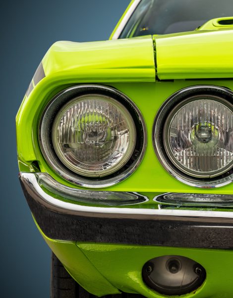 Isolated image of the headlights of a bright green American sports car