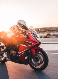 Biking a red motorcycle in the sunset with high speed