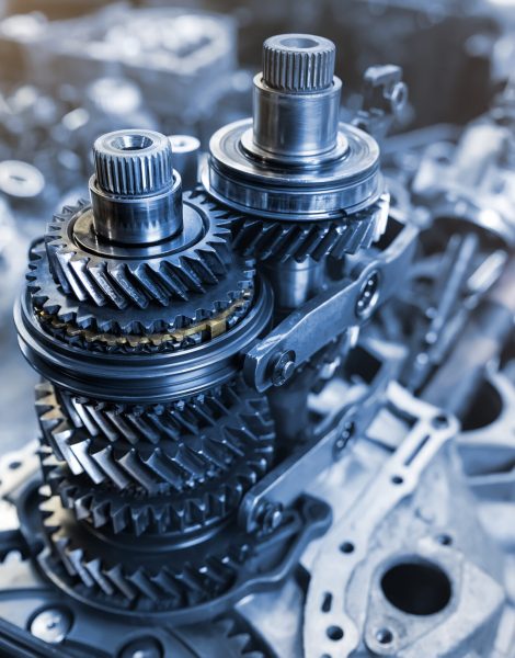 Closeup disassembled car automatic transmission gear part on workbench at garage or repair factory station for fix service or maintenance. Vehicle part detail. Complex industrial mechanism background.