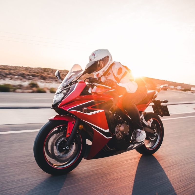 Biking a red motorcycle in the sunset with high speed